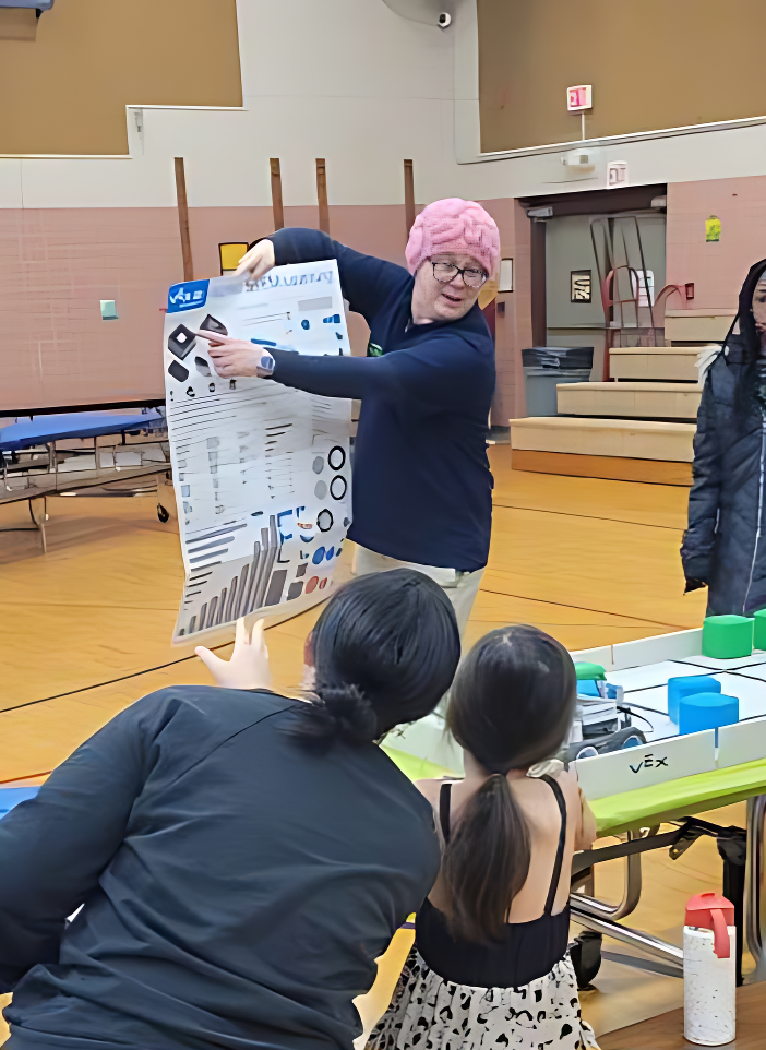 Max teaching families about robotics at a 2025 STEM Day event through STEMNETICS in Flint, Michigan